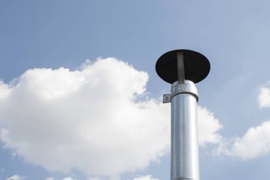 Mavi gökyüzüne karşı bir havalandırma borusunun görüntüsü