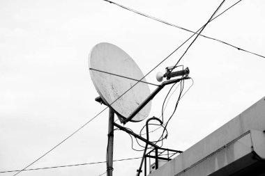Gri gökyüzü arkaplanına karşı uydu anteni