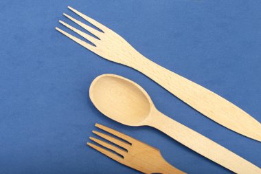 Mavi arka planda ahşap kaşık ve çatal