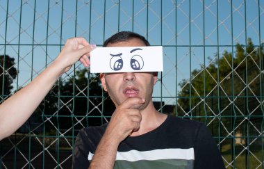 Komik, kağıt gözlü bir adamın portresi.