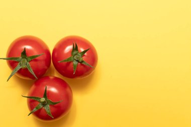 Sarı arkaplanda domateslerin üst görüntüsü