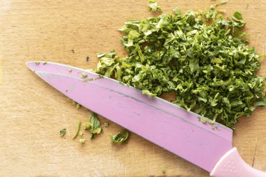 İnce doğranmış bir maydanoz ve pembe bir bıçak.