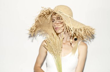 Hasır şapkalı kadın kuru kulaklar tutuyor.