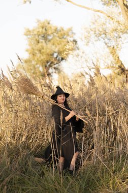 Siyah elbiseli ve şapkalı bir cadı.