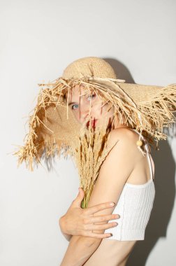 Hasır şapkalı genç bir kadının portresi.