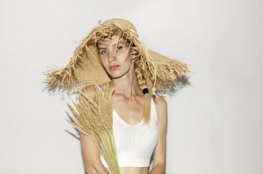 Hasır şapkalı kadın kuru kulaklar tutuyor.