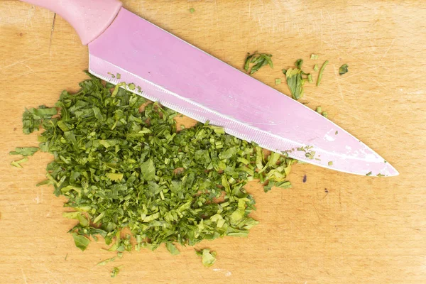 İnce doğranmış bir maydanoz ve pembe bir bıçak.