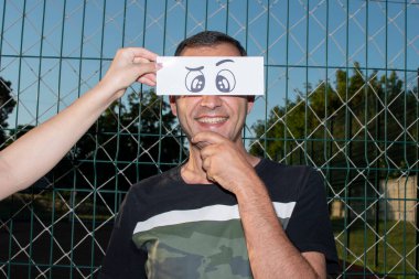 Komik, kağıt gözlü bir adamın portresi.