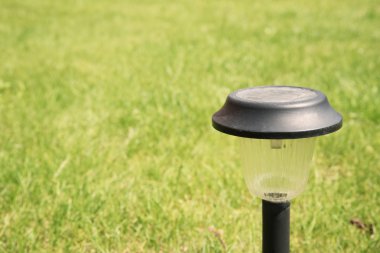 Bir bahçe çim üzerinde güneş enerjili lamba