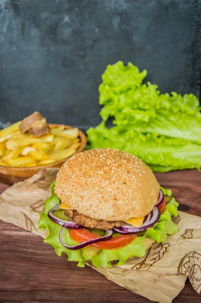 Slaninový burger s hovězí plackou na dřevěném stole — Stock fotografie