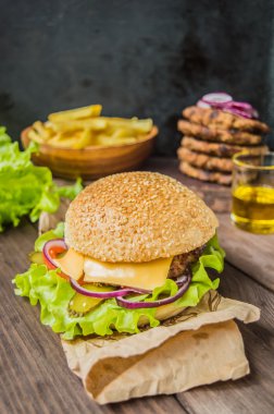 Pastırmalı hamburger ve ahşap masa.