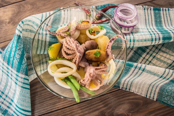 Preparen los anillos frescos de calamar y los tentáculos del pulpo con las patatas cocidas y la verdura en rústico —  Fotos de Stock
