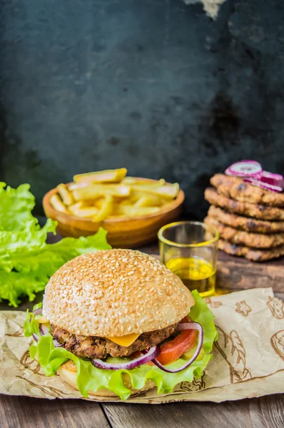 Slaninový burger s hovězí plackou na dřevěném stole — Stock fotografie