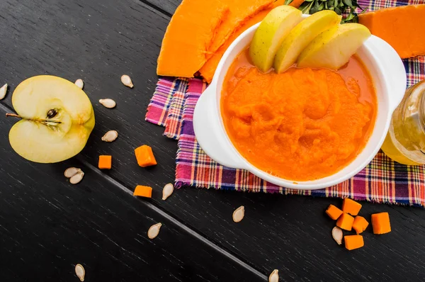 Purée de citrouille aux fruits sur fond de bois noir. Vue du dessus — Photo