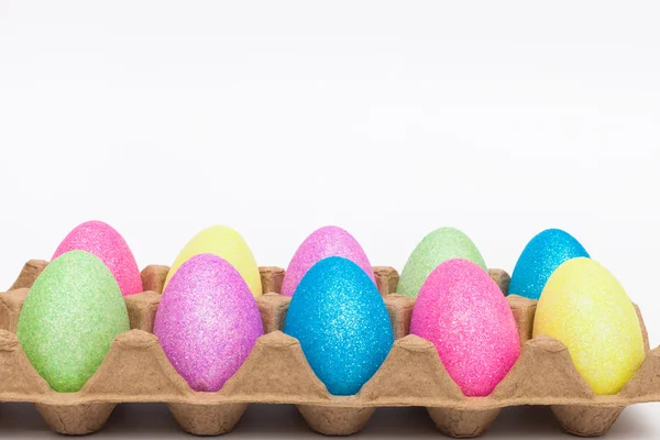 Falsos huevos de Pascua de colores en un cartón — Foto de Stock