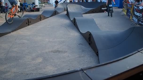 Un niño corre una bicicleta BMX en una pista comunitaria . — Vídeos de Stock