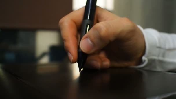 Tableta 19. Primer plano de la mano de un diseñador gráfico sosteniendo un lápiz electrónico. Vista izquierda . — Vídeos de Stock