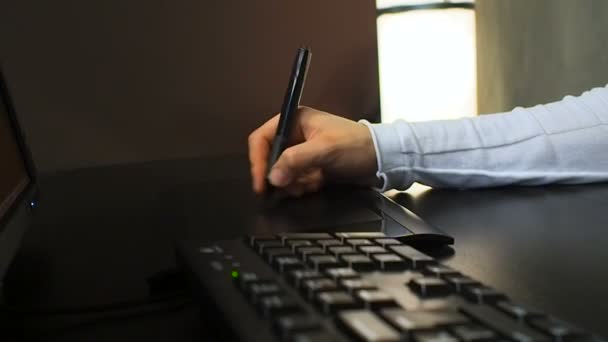 Tablet 23. Nahaufnahme der Hand eines Grafikdesigners mit elektronischem Stift und Tastatur für die Arbeit. Ansicht links. — Stockvideo
