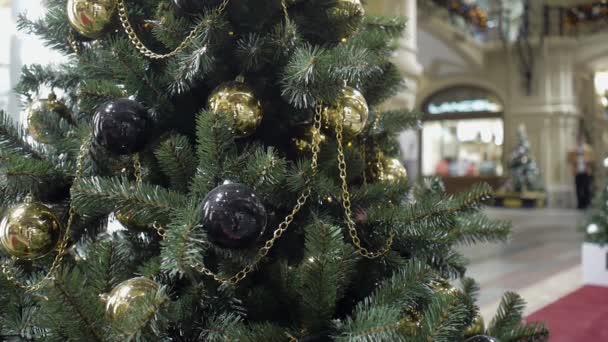 Vídeo en bucle de visitantes caminando detrás de un árbol de Navidad decorado en GUM — Vídeos de Stock