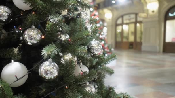 Loopas video av besökare som går bakom en julgran dekorerad med silver bollar i GUM — Stockvideo