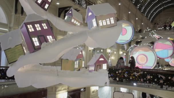 Decoración decorativa de Navidad en forma de casas colgando bajo la cúpula del centro comercial GUM. — Vídeos de Stock