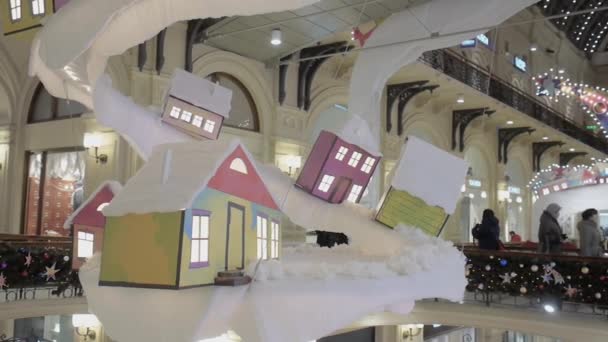 GUM alışveriş merkezinin kubbesinin altında asılı ev şeklinde dekoratif Noel süslemesi. — Stok video