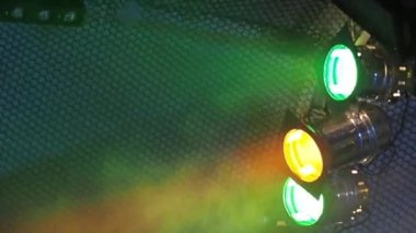 Sahne tavanının altındaki siste üç klasik sahne ışıkları yanıp sönüyor.