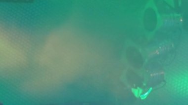 Sahne tavanının altındaki yeşil siste üç klasik sahne ışıkları yanıp sönüyor.