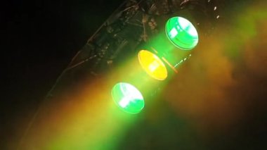 Sahne tavanının altındaki sisin içinde üç klasik sahne ışıkları yanıp sönüyor.