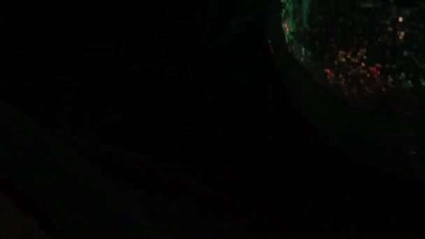 En disco boll med ett hörn av ramen belyses periodvis av en spotlight i en loop — Stockvideo
