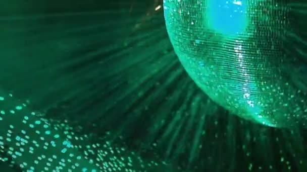 A tükrözött diszkógömböt zöld fényszóró világítja meg, és egy hurokban erős fénysugarakat bocsát ki. — Stock videók