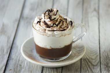 Fincan Cappuccino ahşap masa üzerinde Whipeed krema ile