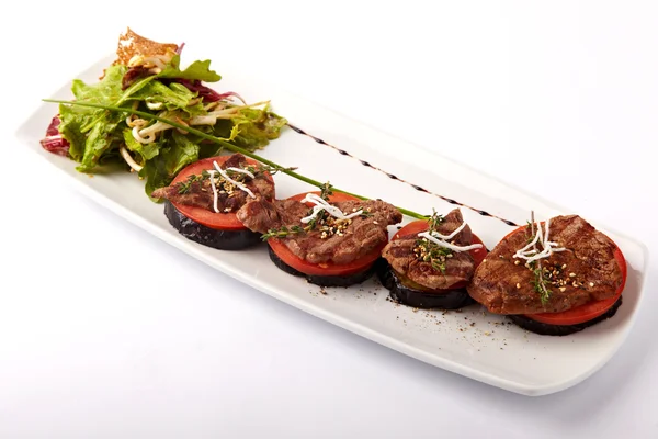 Beef medallions on tomato and grilled eggplant on a white plate — Stock Photo, Image