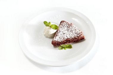 Dondurma ve pudra şekeri, beyaz bir tabağa yakın çekim ile çikolatalı kek