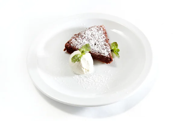 Tort czekoladowy z lodami i cukier puder, szczegół na białym talerzu — Zdjęcie stockowe