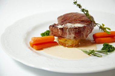 Havuç, ızgara biftek yakın çekim üzerinde beyaz izole