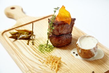 Beyaz izole kesme tahtası üzerinde patates soslu ızgara et