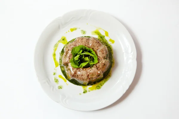 Carne de cerdo y ternera gelatinosa en un plato, de cerca aislada en blanco — Foto de Stock