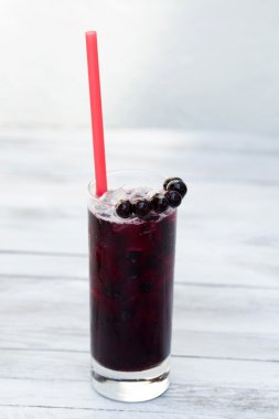 Blackcurrant limonata bir bardak buz üstünde tahta arka plan ile