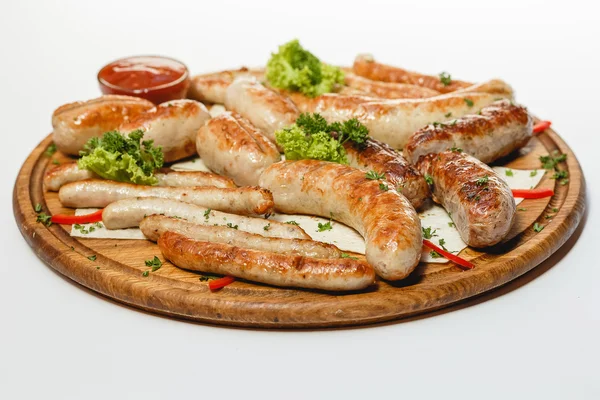 Различные виды жареных колбас на деревянной тарелке на белом фоне — стоковое фото
