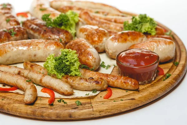 Different kind of grilled sausages on the wooden plate on white background — Stock Photo, Image