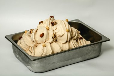 Beyaz arka plan üzerinde metal tepsi içinde fındık çeşitleri ile dondurma