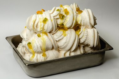 Beyaz arka plan üzerinde metal tepsisinde şekerlenmiş kabuğu ile beyaz dondurma