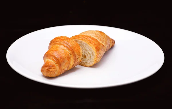 Két fele friss sült croissant, fehér lemez — Stock Fotó