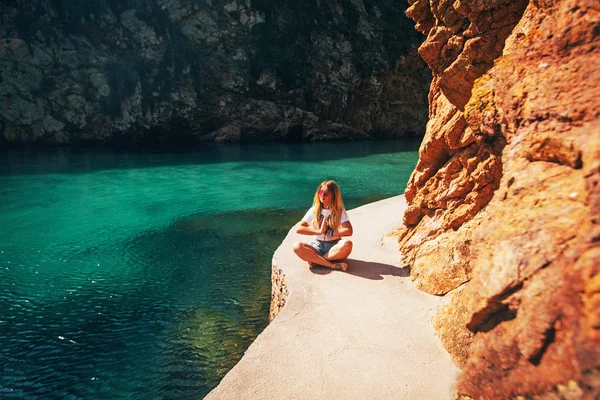 Girl meditates on rock — Stock Photo, Image