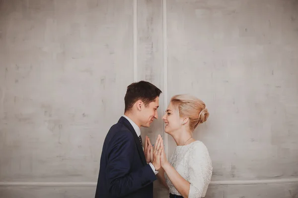 Bruden och brudgummen på väggen bakgrund — Stockfoto