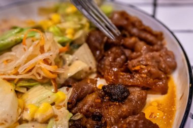 Bir çatalın Macro görüntüsü. Bol sos ve baharatla kaplı lezzetli bir parça et alıyor..