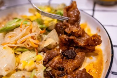 Bir çatalın Macro görüntüsü. Bol sos ve baharatla kaplı lezzetli bir parça et alıyor..