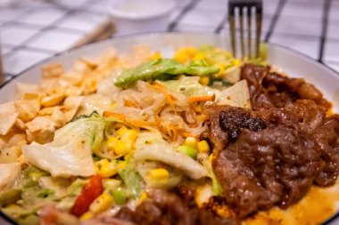 Bir çatalın Macro görüntüsü. Bol sos ve baharatla kaplı lezzetli bir parça et alıyor..