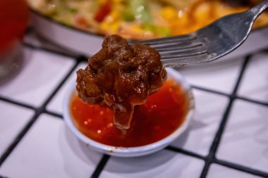 Çağdaş bir arkaplana karşı tatlı acı biber sosuna batırılan lezzetli ve lezzetli bir et..